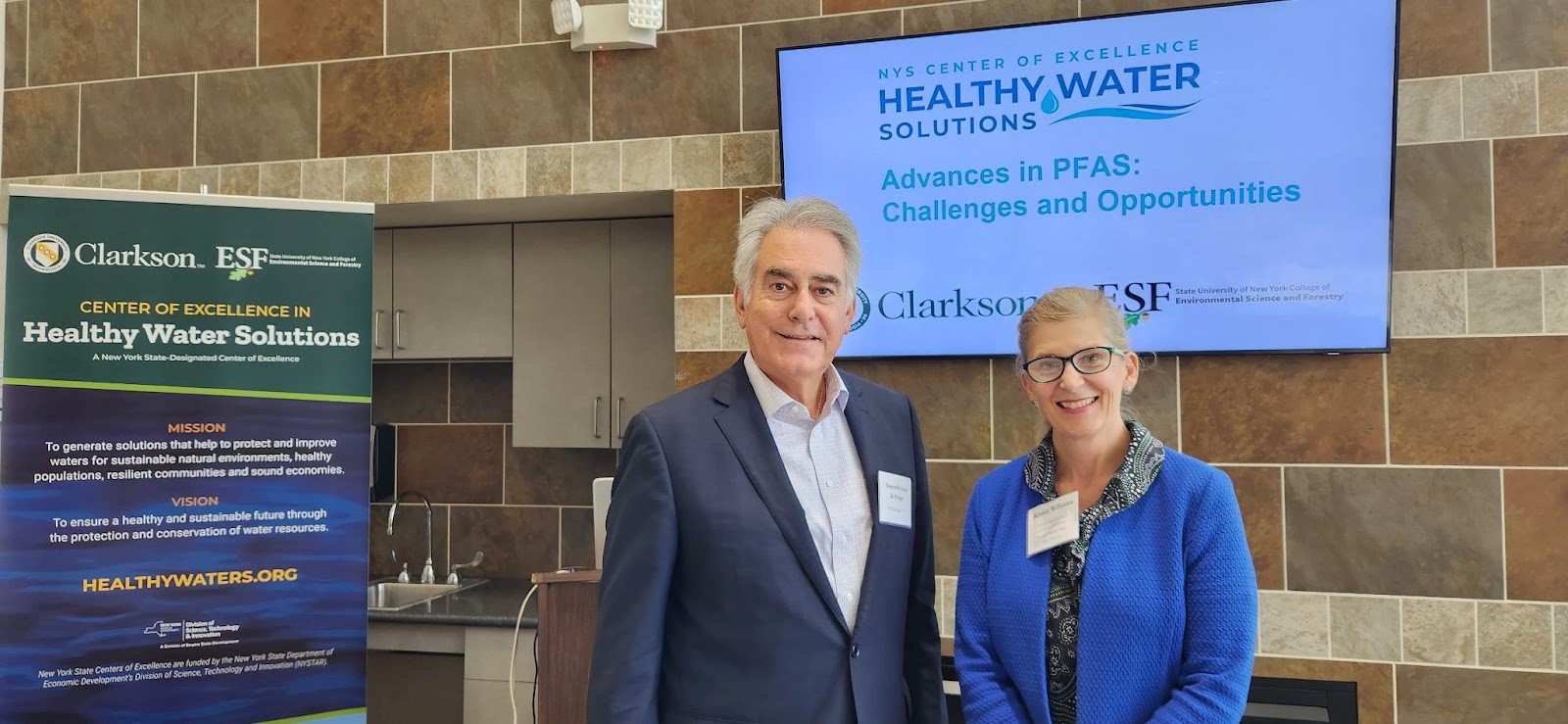  Two presenters stand in front of Healthy Water Solutions banners at Clarkson's Capital Region Campus.