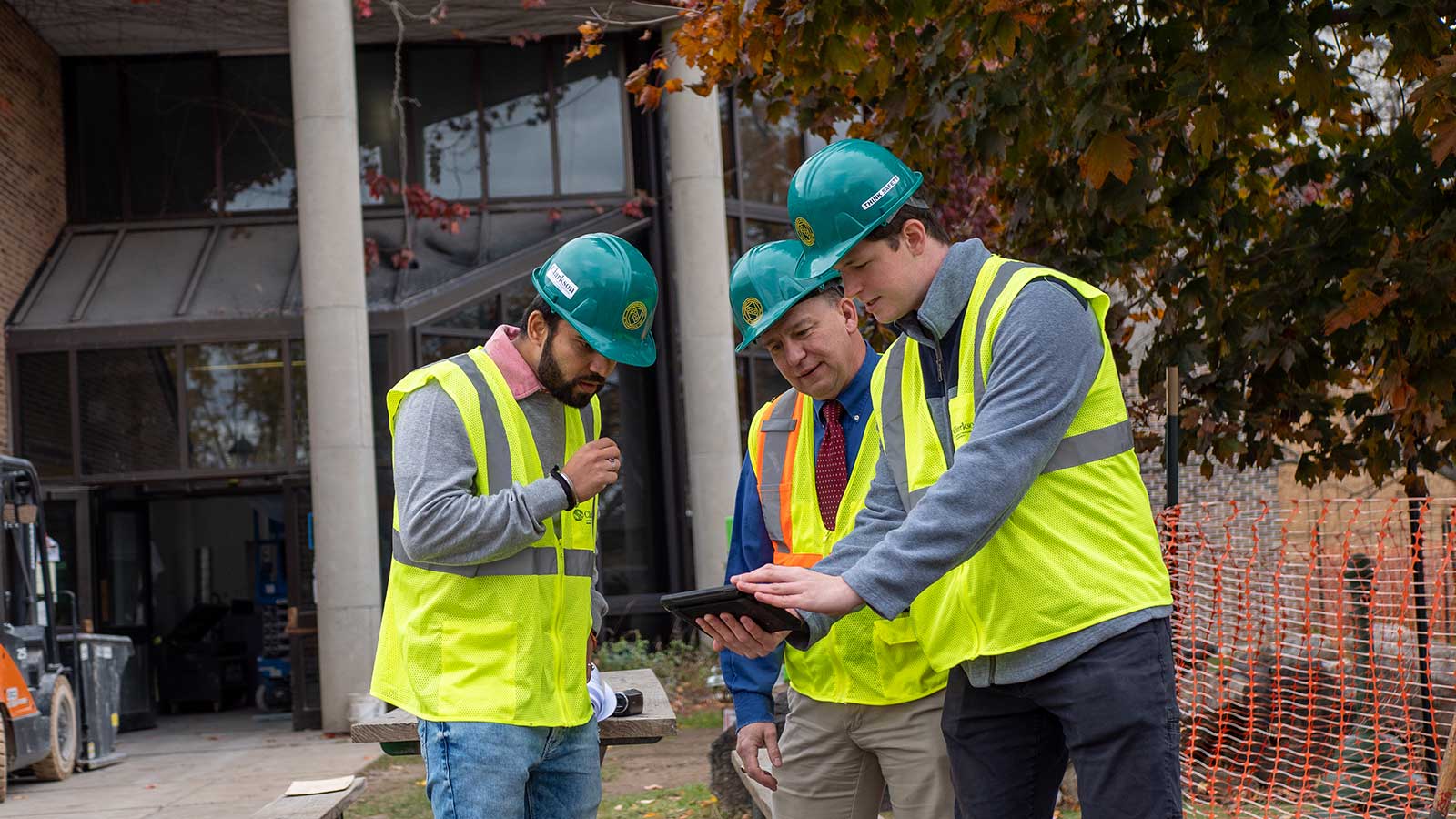 Construction Engineers looking at a tablet on a job site representing construction engineering management program at Clarkson university 