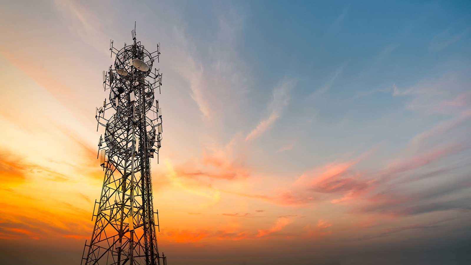 Communications tower at sunset representing Electrical Engineering programs at Clarkson University