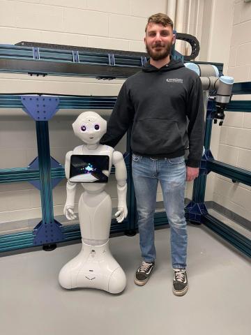 Graduate student Joseph Dibble with the Pepper robot, which will be used in the project