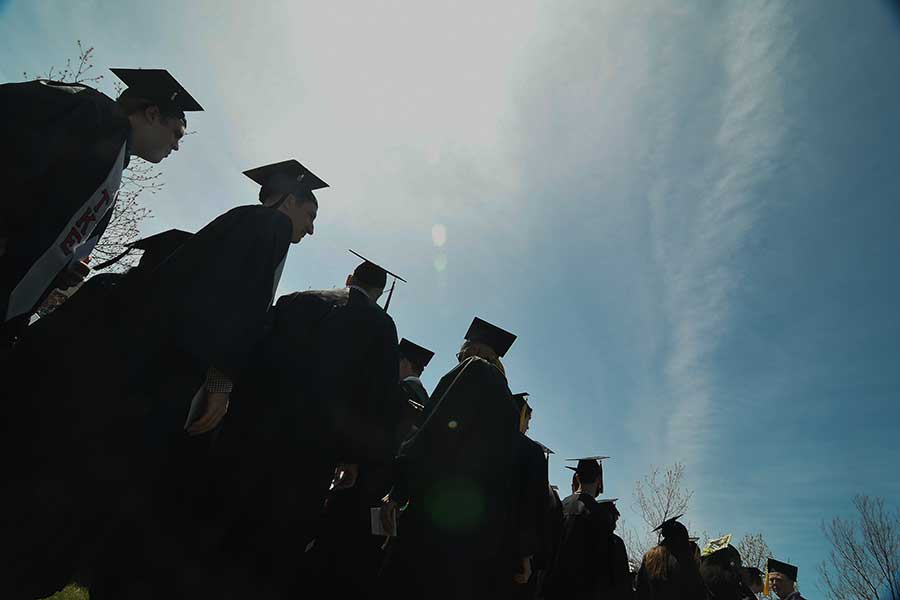Students at commencement in  silhouette