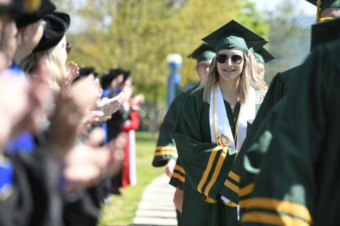 a Clarkson University student in sunglasses is cheered by faculty