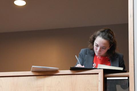 a woman writes on a notepad