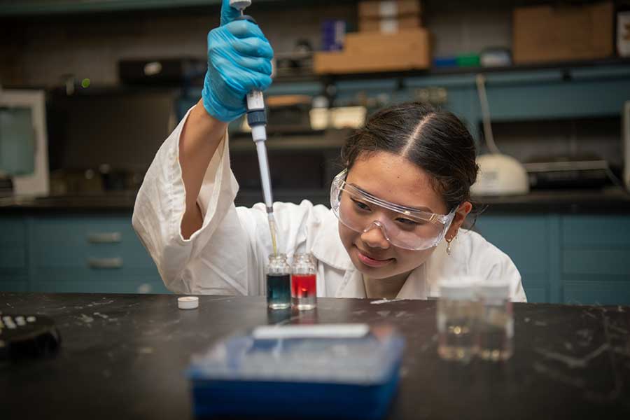 Student conducting experiment in lab.