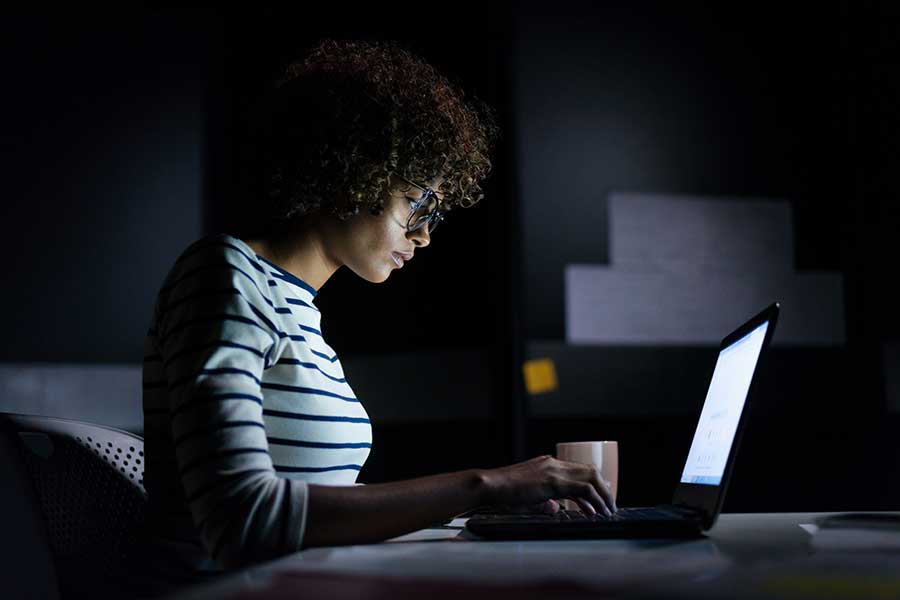 Individual working on a computer at night