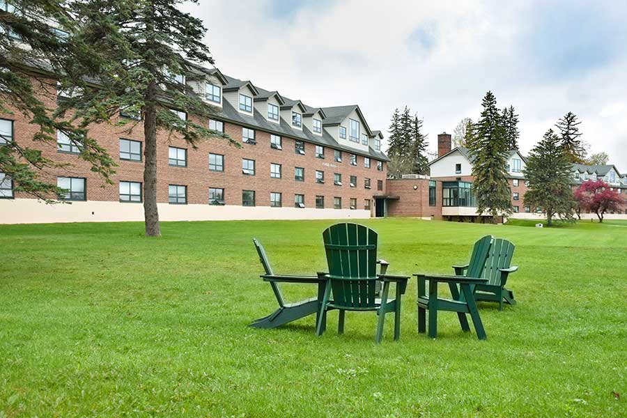 Adirondack chairs in front of the dorms