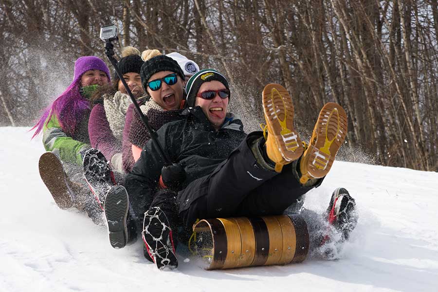 Students riding in a toboggan at winter fest