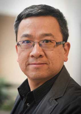 Shoulders-up portrait of Chen Liu in a grey sports jacket and black shirt