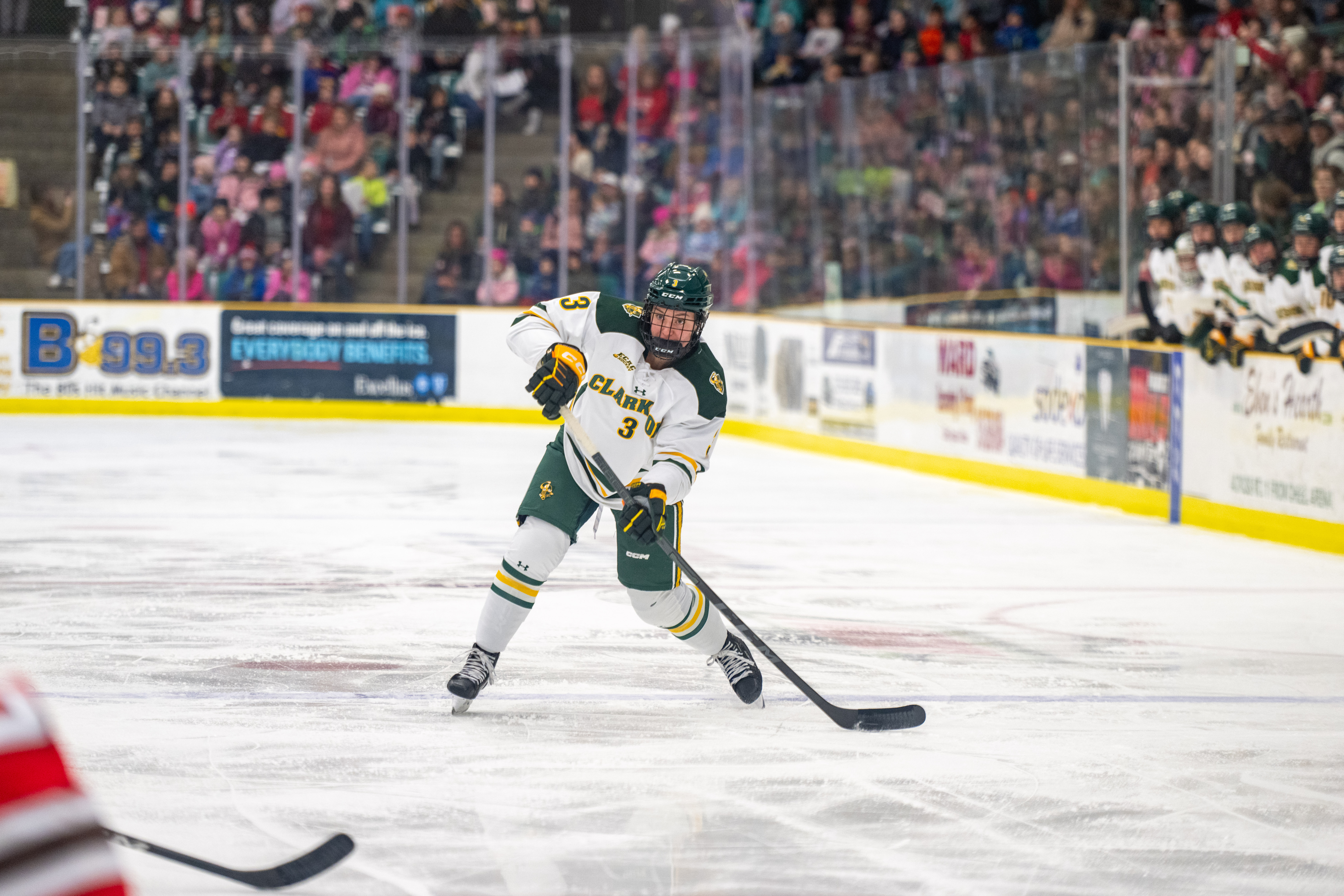 A Clarkson women's hockey player shoots a puck during a game.