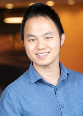 Shoulders-up portrait of Leo Jiang in a light blue, open-collar shirt