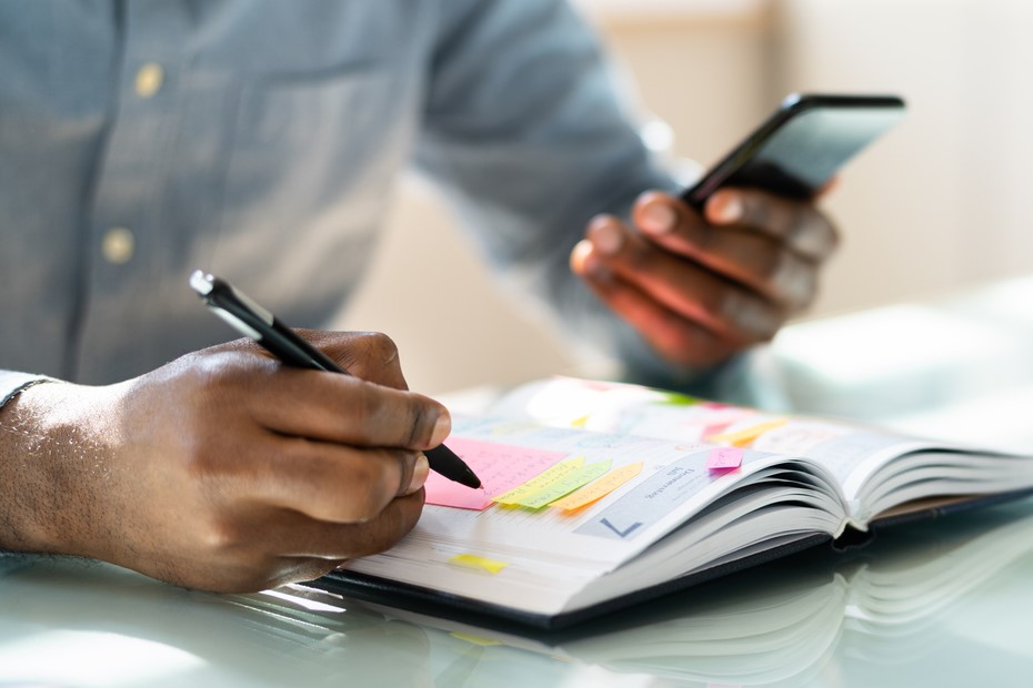 A man writing in his weekly planner