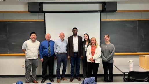Students pose for a photo with members of the OBPA in front of a blackboard