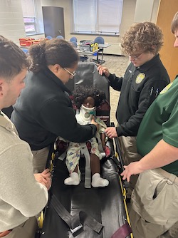 EMT students practice techniques on a doll.
