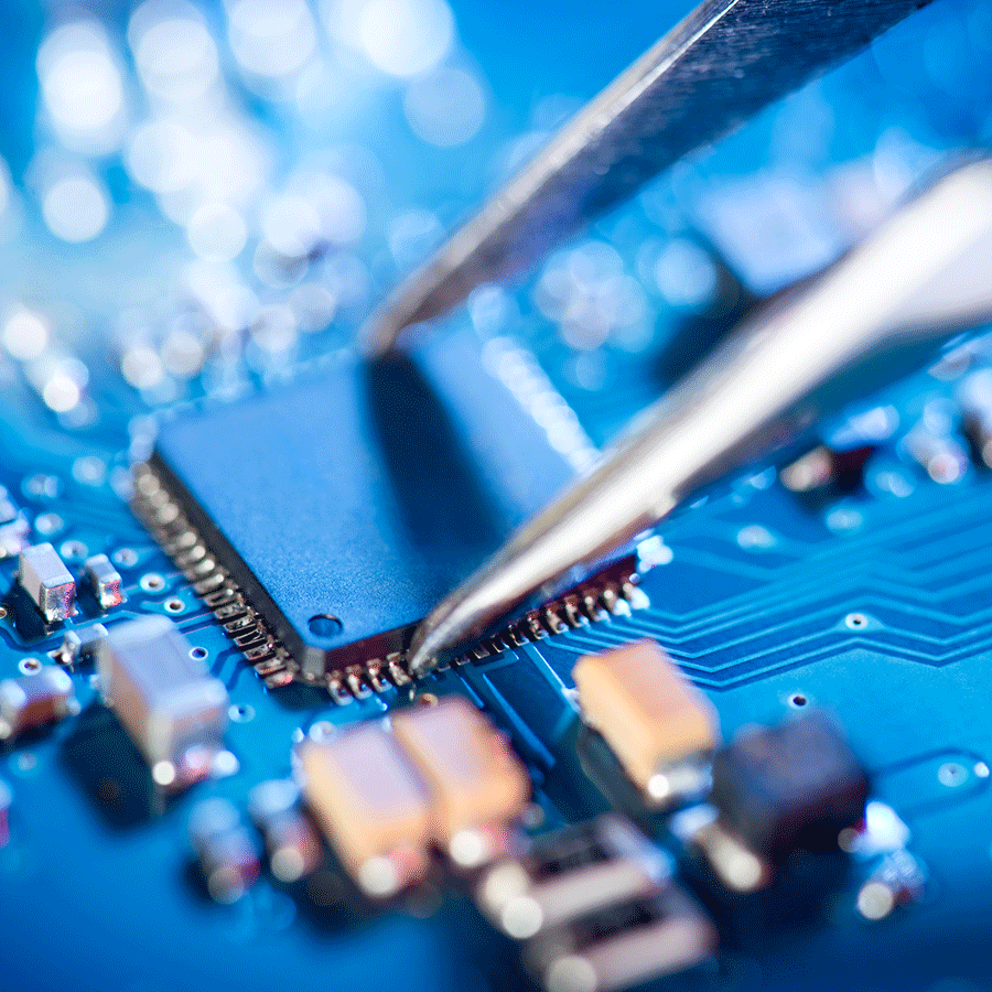 Electronic technician holding tweezers and assembling a circuit board.