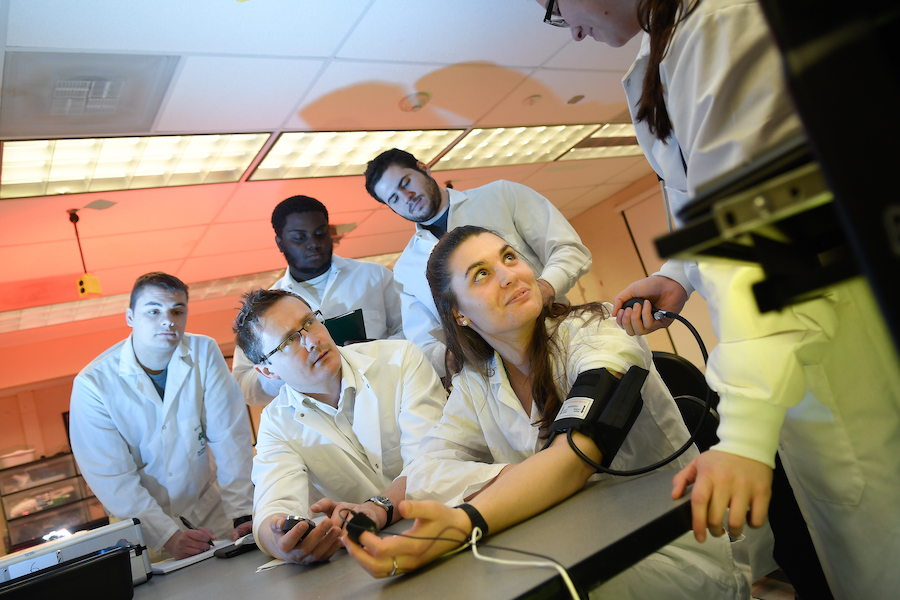 Students practice medical tests on each other in Clarkson University's neuroscience lab.