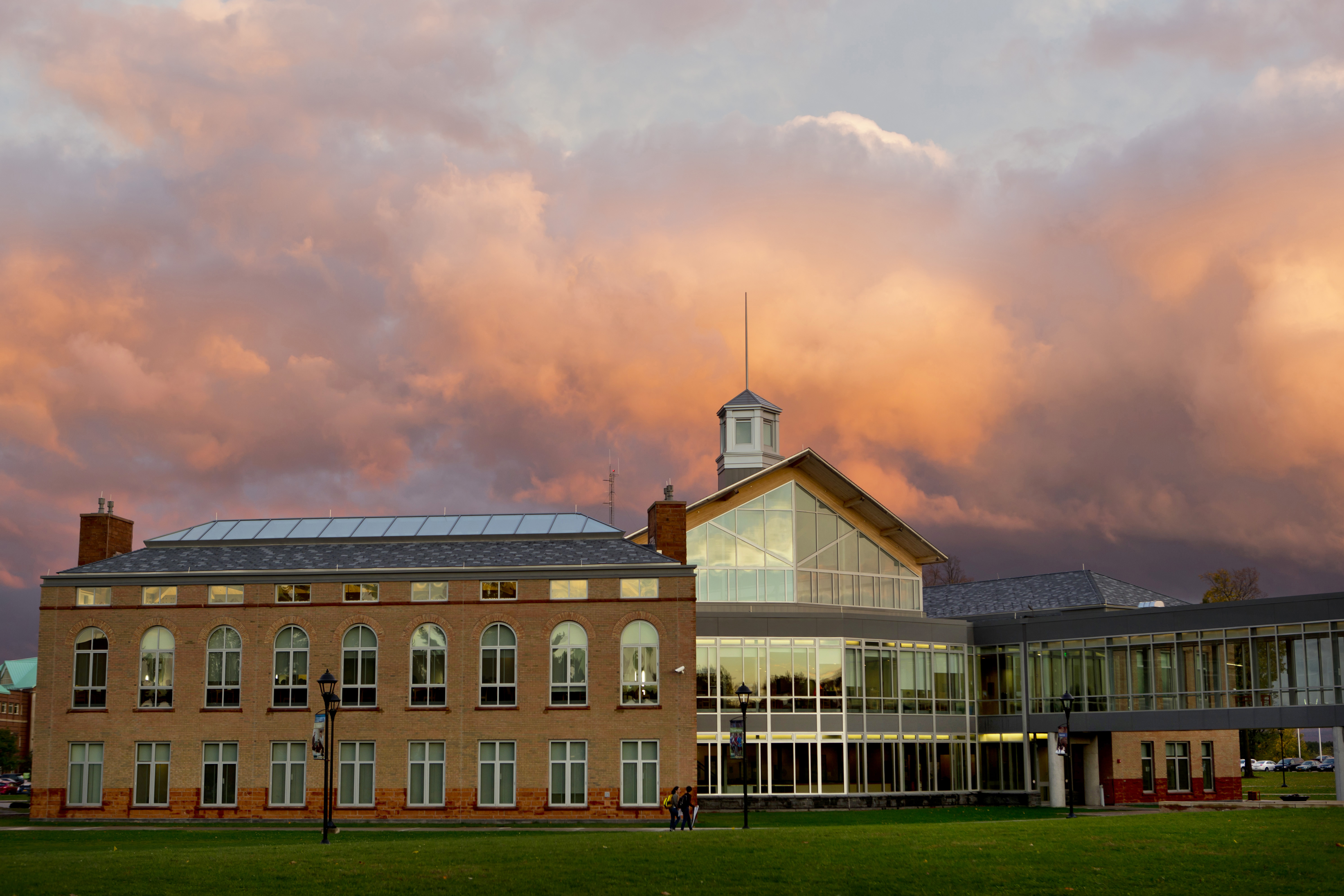 Wide view of a Clarkson University campus building beneath a colorful sunset sky.